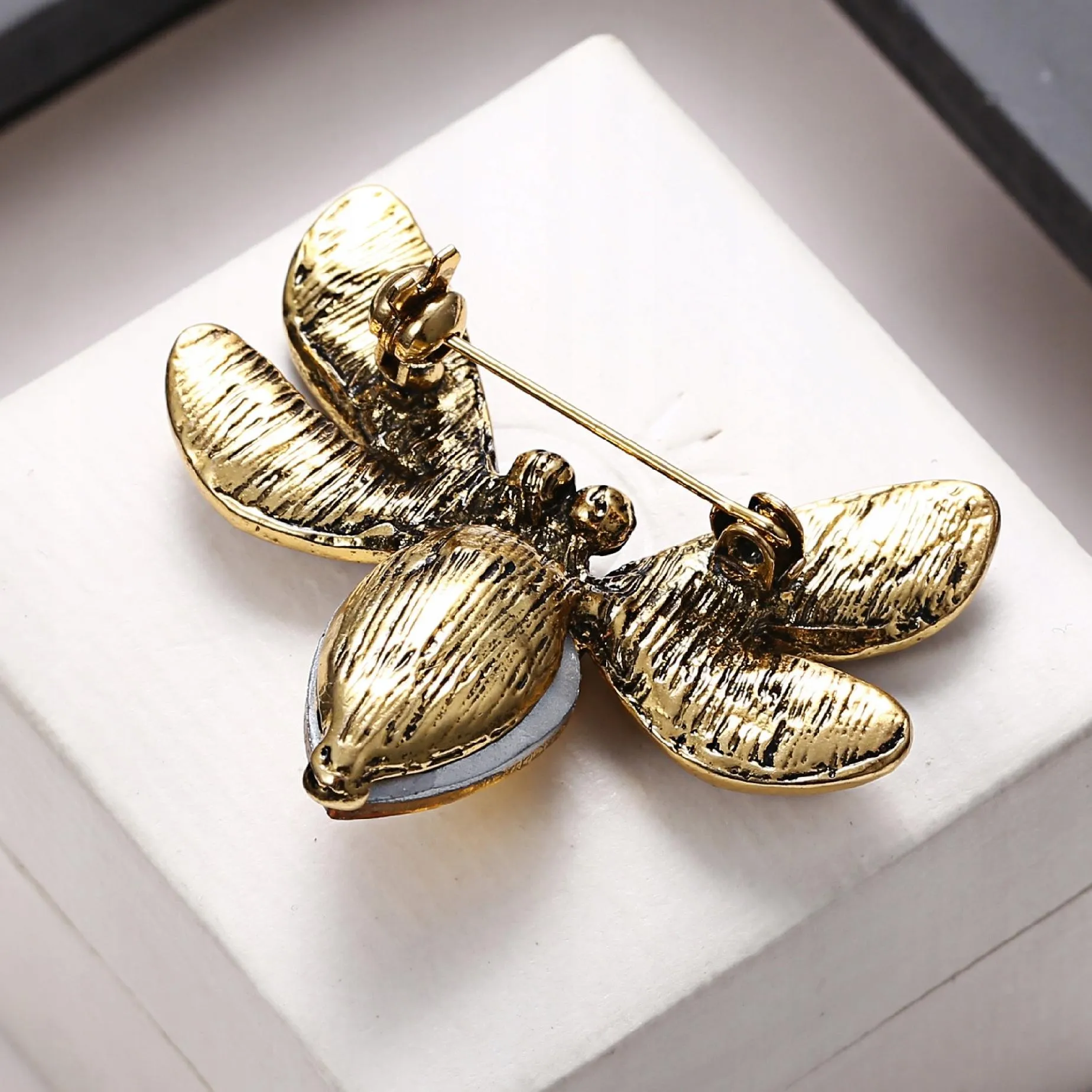 Yellow insect brooch with zircons